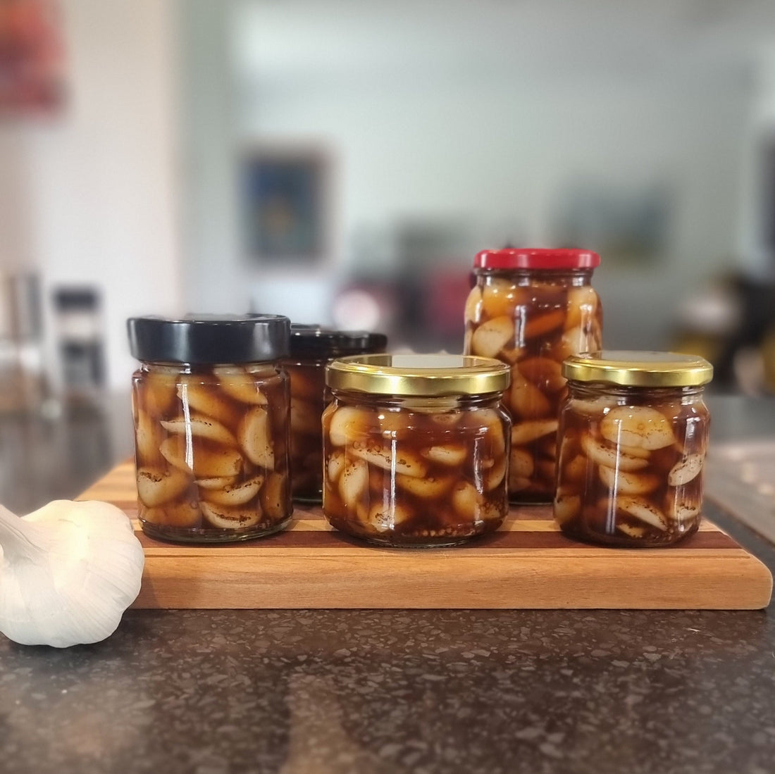 Jars of pickled garlic sitting on a wooden board