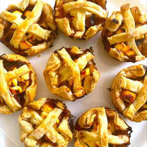 Black Honey onion tartlets with criss cross pastry tops in a circle on a plate