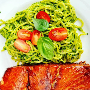 green spaghetti and salmon on a plate. 