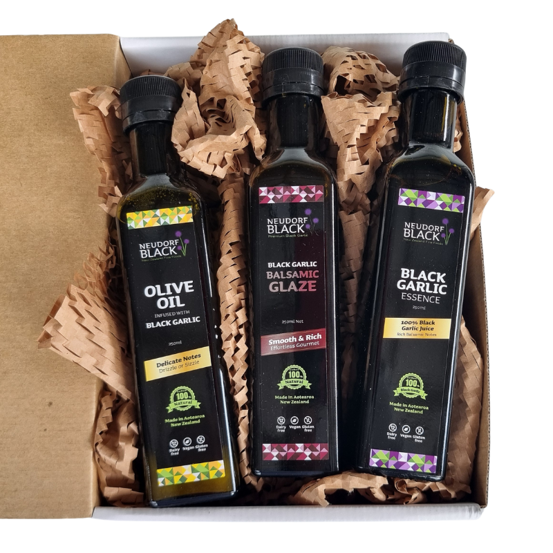 Three bottles of Neudorf Black products in a box with brown tissue paper.