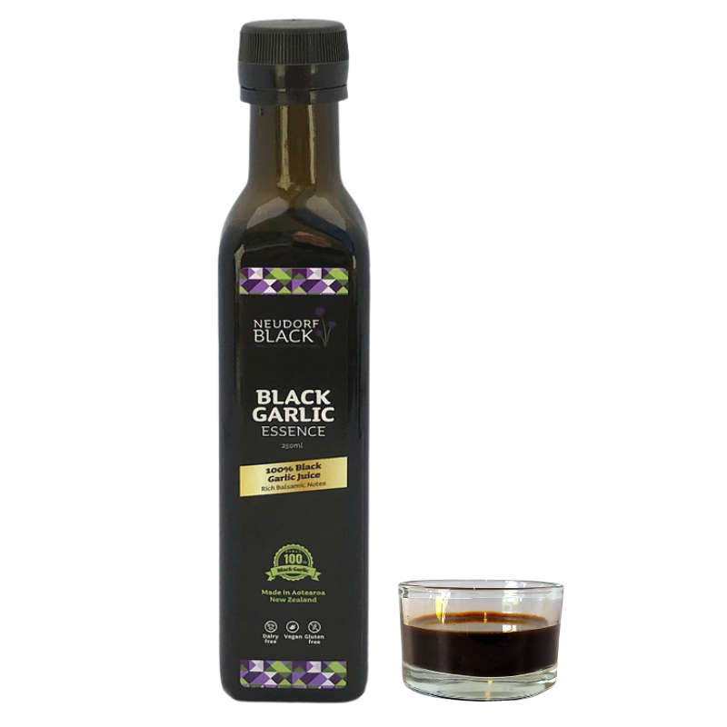 Close-up of Black Garlic Essence 250ml bottle with rich black liquid gold beside it – sweet and savoury umami glaze alternative
