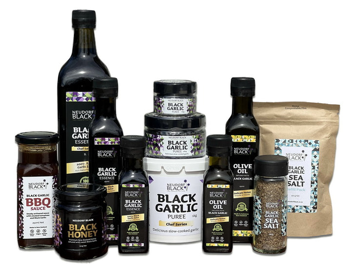 Bottles of labelled Black Garlic products arranged on a white background