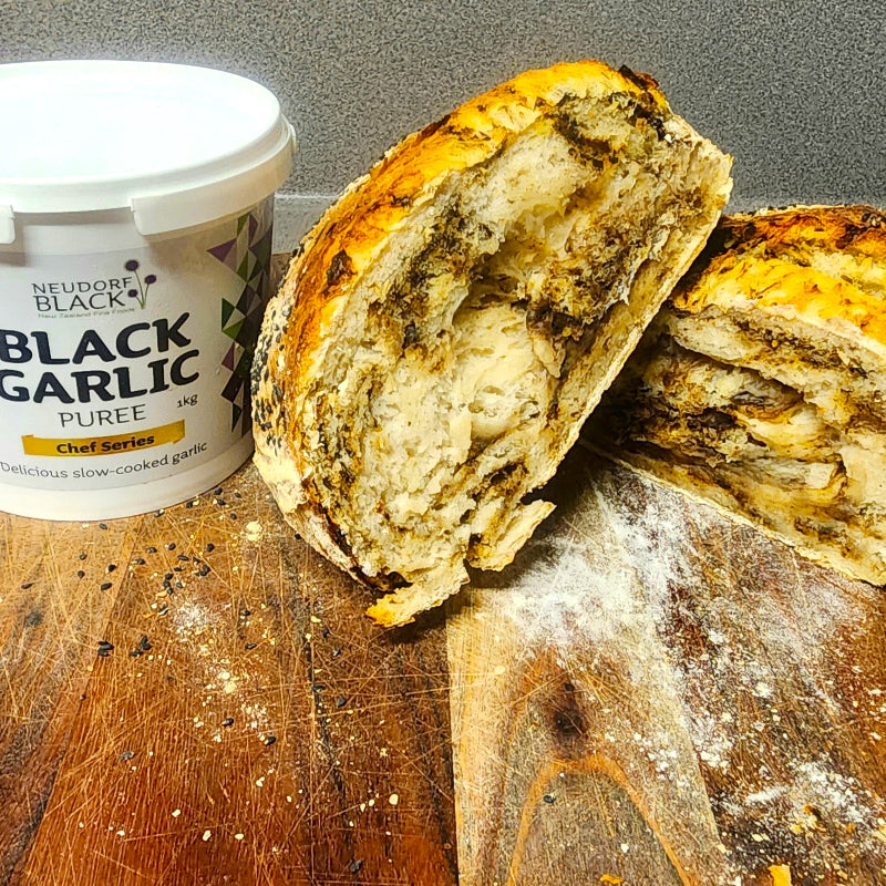 Bread with Neudorf Black black garlic puree on a wooden surface