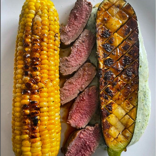 Sweetcorn, lamb and courgette with black garlic honey on a plate