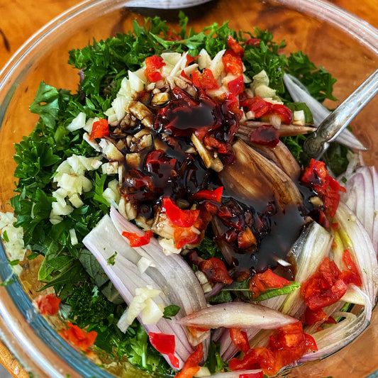 chimichurri ingredients in a bowl, including black garlic honey