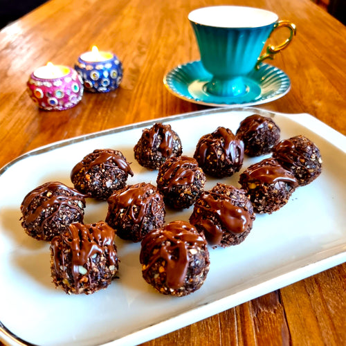 bliss balls made with Black garlic honey and drizzled with chocolate arranged on a plate