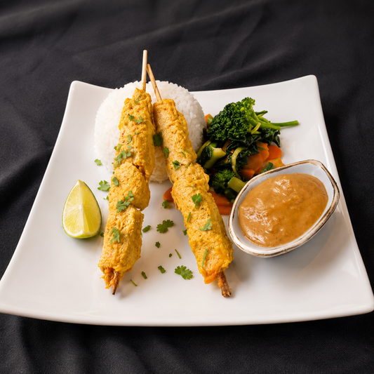easy peanut sauce made with black garlic hot honey in a bowl beside satay sticks