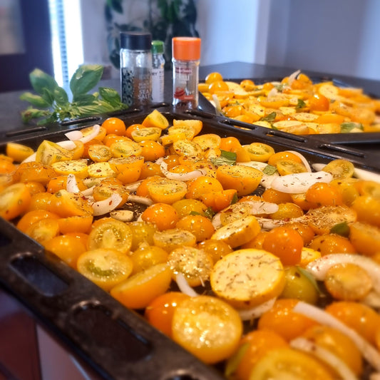 sliced yellow tomatoes on a roasting tray ready to cook