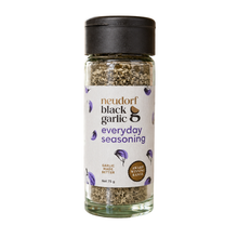 A shaker jar of Neudorf Black Garlic Everyday Seasoning with a white label and black cap, set against a plain white background.