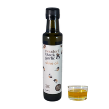 A bottle of Neudorf Black Garlic Olive Oil with a sample of the golden oil beside it in a glass container.