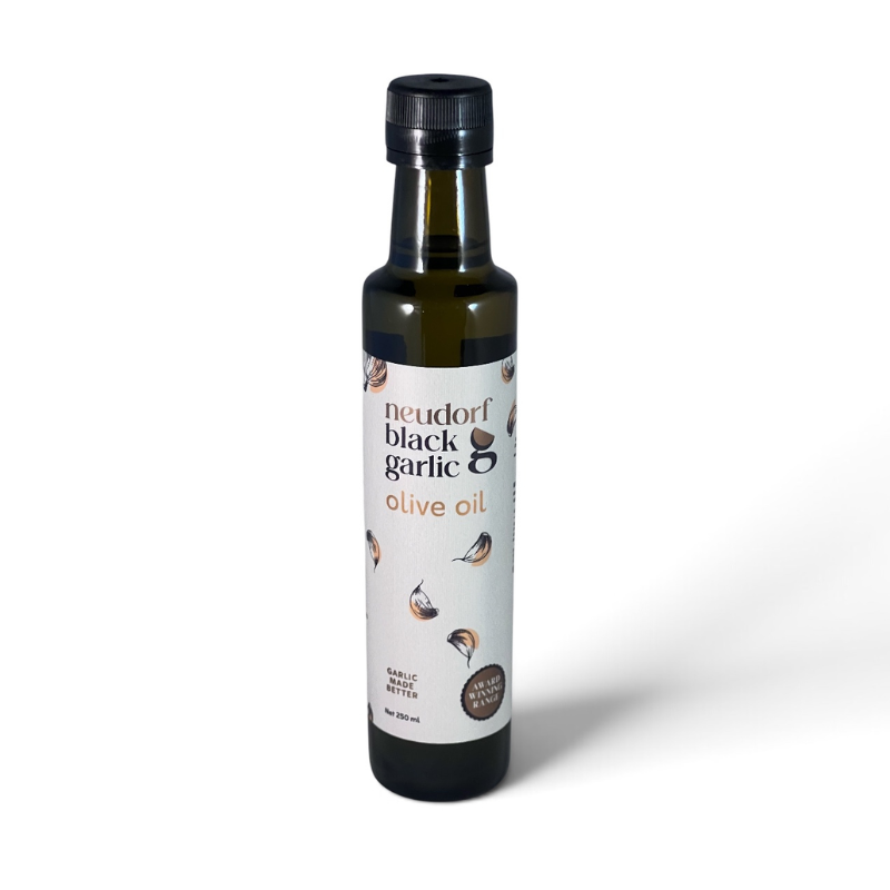 A bottle of Neudorf Black Garlic Olive Oil on a clean white background. The dark glass bottle features a black cap and a white label with illustrations of garlic cloves and text reading 'neudorf black garlic olive oil'.