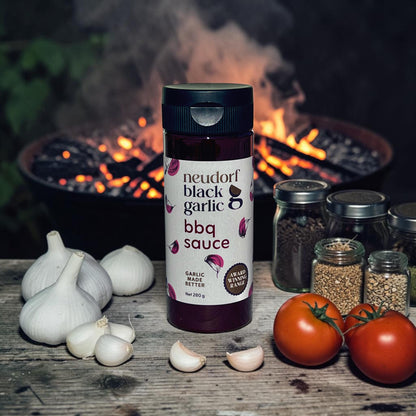 Neudorf Black Garlic bbq sauce on a wooden table with a firepit in the background