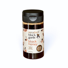 A 250g jar of Neudorf Black Garlic Honey with a black lid and a cream-colored label, shown on a plain white background.